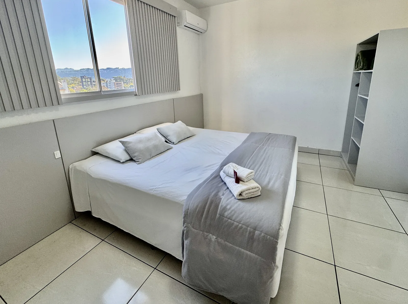 Quarto de casal com armário e vista da cidade